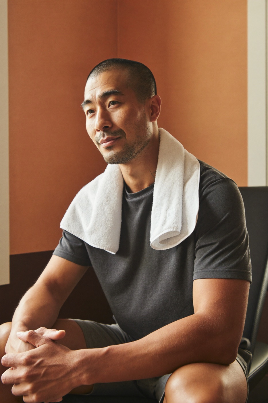 A man resting with a towel after a workout at home